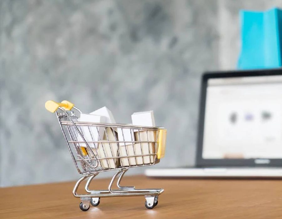 Small shopping cart next to a laptop